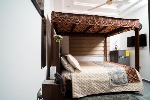 a bedroom with a bed with a canopy at Cherry Signature Condos in Adentan