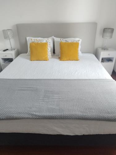a white bed with two yellow pillows on it at Alexia Room in Funchal