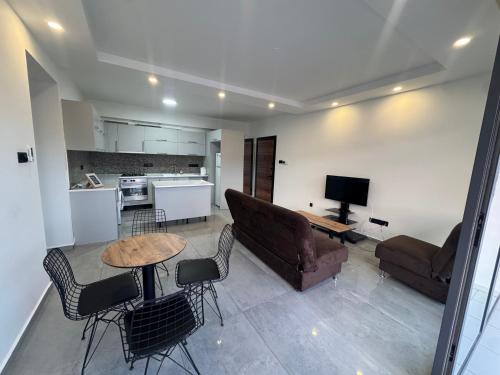 a living room with a couch and a table and chairs at Joy Residence- 3 bedroom apartment with balcony in Nicosia