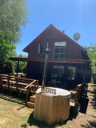 a house with a hot tub in front of a house at Cabaña Vista Las Bravas in Recinto