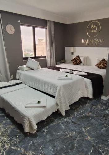 two beds sitting next to each other in a room at Harmonia Flat's - Aeroporto Gru in Guarulhos