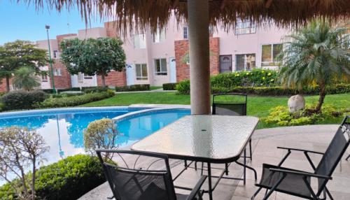 a table and chairs next to a swimming pool at Escapada con Alberca en Xochitepec in Xochitepec
