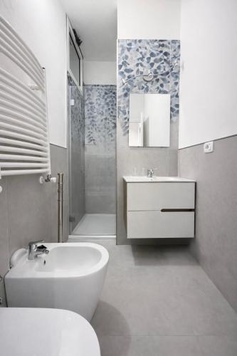 a white bathroom with a sink and a toilet at Hotel Sinuessa Terme in Mondragone