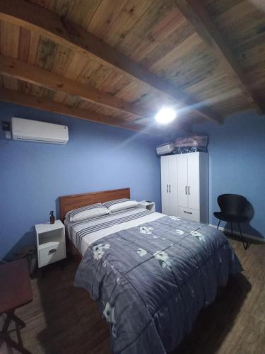 a bedroom with a bed and a blue wall at Grazie Carpe in Jaureguiberry