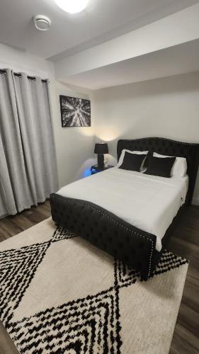 a bedroom with a large bed and a rug at Hebzibah's Luxe in Prince George