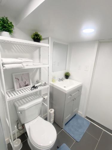 a white bathroom with a toilet and a sink at ClassicPavillion INN in Bowmanville