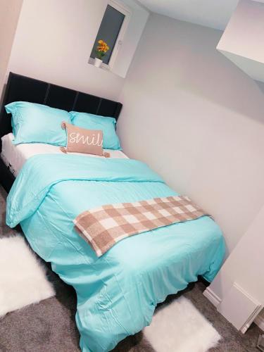 a small bedroom with a bed with blue sheets at ClassicPavillion INN in Bowmanville
