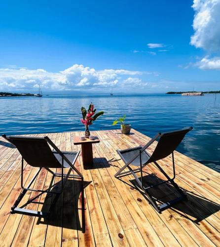 deux chaises et une table sur un quai au bord de l'eau dans l'établissement Blue Marlin, à Bocas del Toro