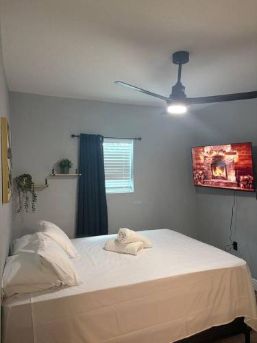 a bedroom with a white bed with a ceiling fan at Amelia’s Arena Retreat in Orlando