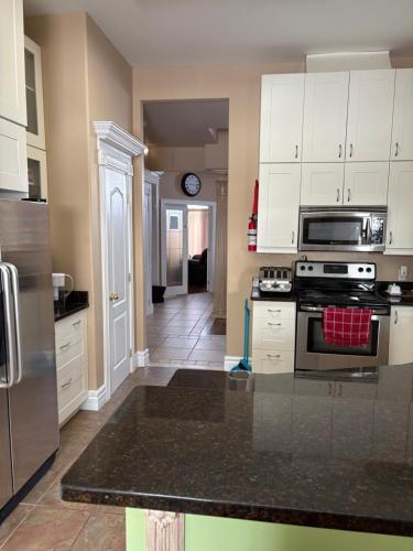 a kitchen with white cabinets and a stove top oven at Lakeview in Colborne