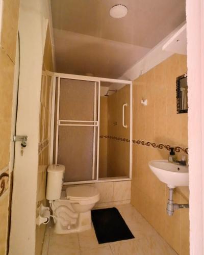 a bathroom with a toilet and a sink at Casa Grulla in Santa Marta