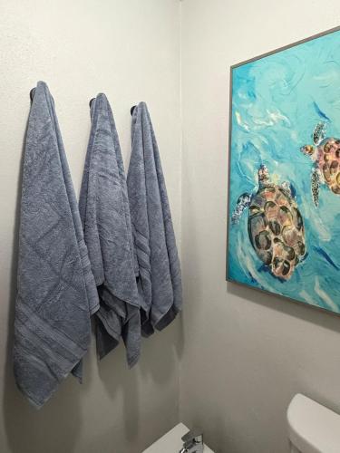 a bathroom with blue towels hanging on a wall at NaboBlue Ocean View Apartment Maunabo PR in Maunabo