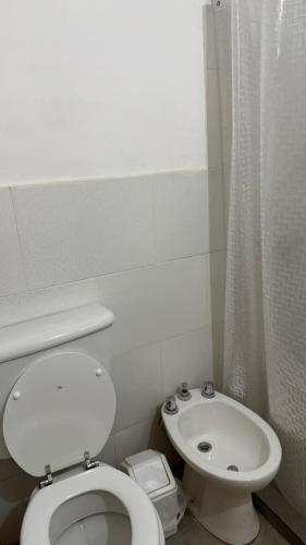 a white bathroom with a toilet and a sink at Departamento Céntrico Equipado in San Fernando del Valle de Catamarca