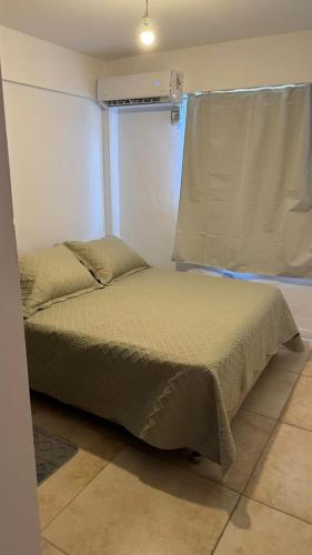 a small bed in a room with a window at Departamento Céntrico Equipado in San Fernando del Valle de Catamarca