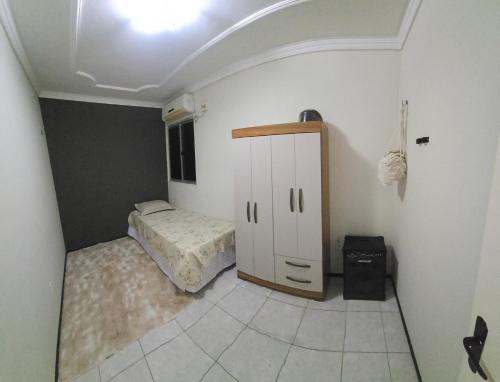 a bedroom with a small bed and a small cabinet at Tesouro da Maraponga in Fortaleza