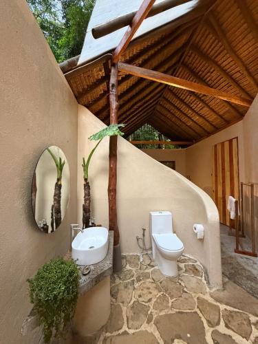a bathroom with a toilet and a sink at Dalakit House Hidden Garden Oasis in Lambojon