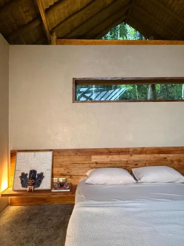 a bedroom with a white bed and a window at Dalakit House Hidden Garden Oasis in Lambojon