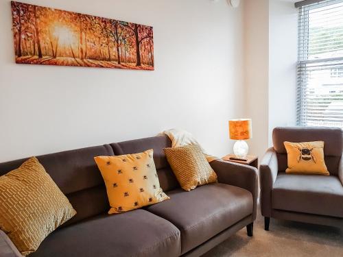 a living room with a brown couch and a chair at Invergyle - Uk40566 in Falkland
