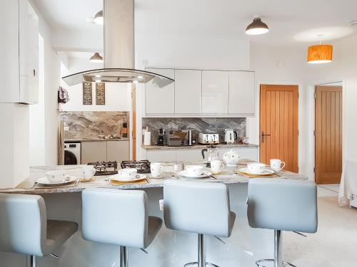 a kitchen with a large island with chairs in it at Invergyle - Uk40566 in Falkland