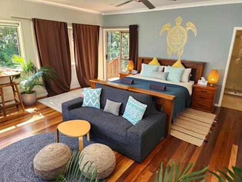 a bedroom with a bed and a couch at Cosy Studio with Forest Views, Noosa Hinterland in Doonan