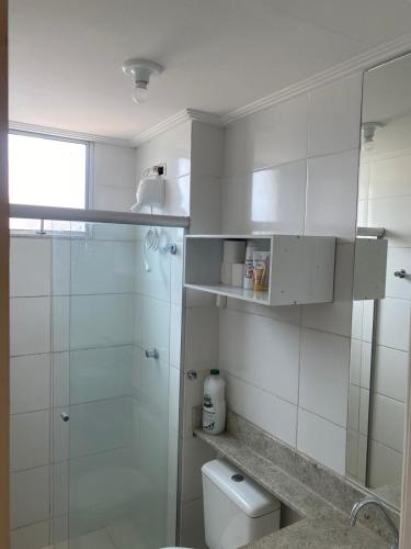a white bathroom with a shower and a toilet at Lar doce lar! in Divinópolis