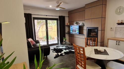 a living room with a couch and a table at Sauvage - Spacious Apartment with Private Garden Courtyard in Port Pirie