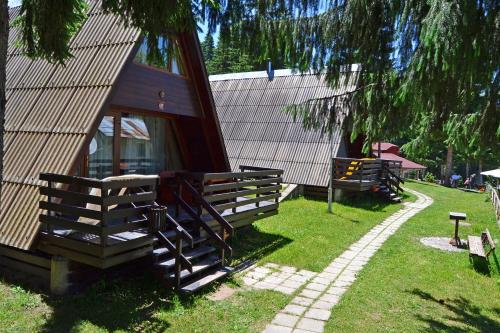 a house with a fence next to a yard at Romantica Forest Guest House in Dospat
