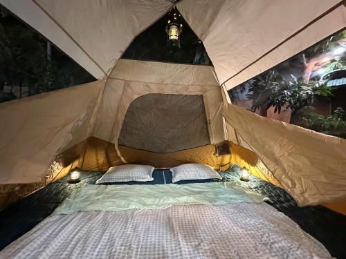 a bed in a tent with two pillows at Homestay & Camping Phan Thiet Beach in Ấp Bình Hưng
