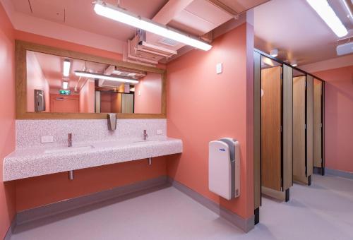 a bathroom with two sinks and a large mirror at LyLo Auckland in Auckland