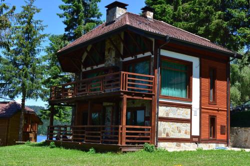a large wooden house with a roof at Romantica Forest Guest House in Dospat