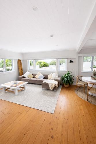 a living room with a couch and a table at Lukes Kitchen Bach in Kuaotunu