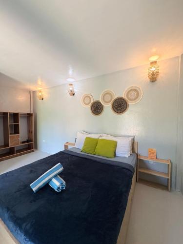 a bedroom with a bed with two baseball bats on it at Jaydy Guest House in General Luna