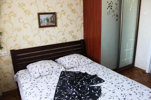 um quarto com uma cama com um cobertor preto e branco em Apartments on Pechersk em Kiev