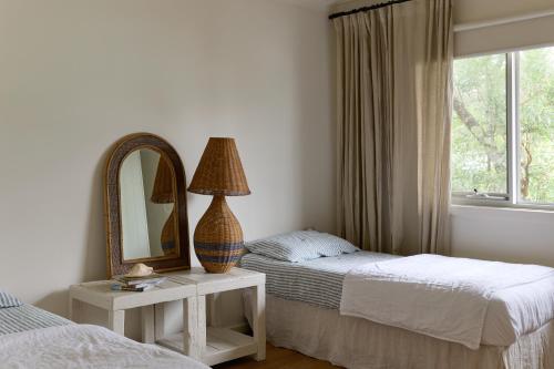 a bedroom with two beds and a mirror at Verandah Retreat - A Beach House by the sea in Cowes