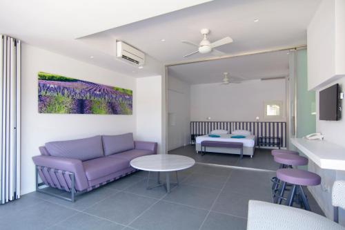 a living room with a purple couch and a table at Lavender Cove in Korfos