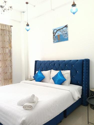 a blue bed with a blue headboard in a bedroom at Mandala Beach Villa Jomtiean in Jomtien Beach