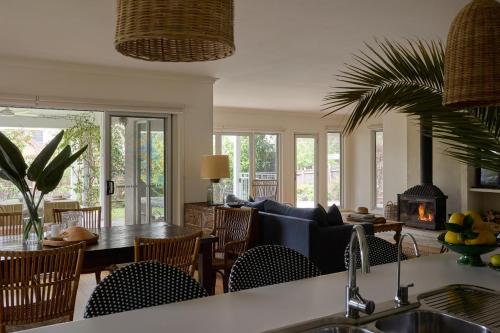 a kitchen and living room with a couch and a fireplace at Verandah Retreat - A Beach House by the sea in Cowes