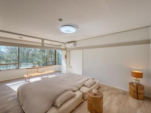a bedroom with a large bed and a large window at Oyado S in Hakone