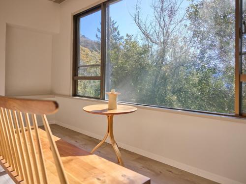 a table and a chair in a room with a window at Oyado S in Hakone