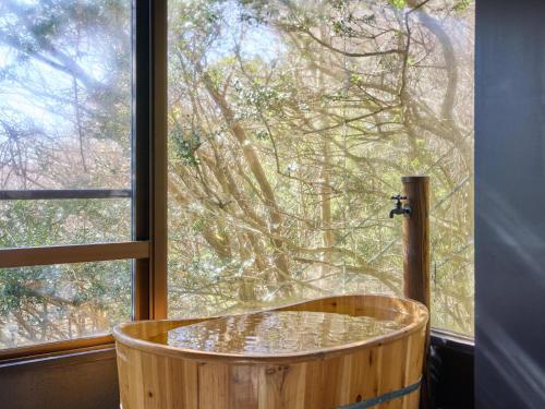 a wooden tub in front of a window at Oyado S in Hakone
