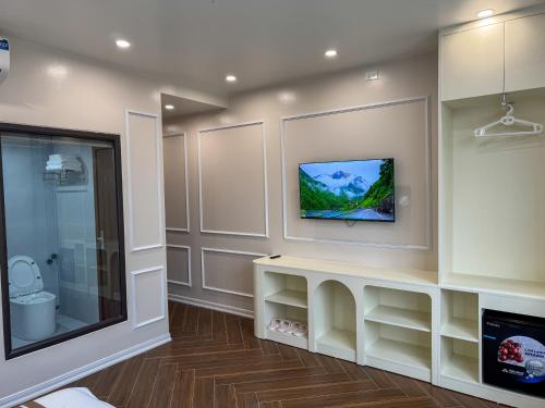 a bathroom with a toilet and a tv on the wall at New Hotel Phủ Lý in Trượng Trâu