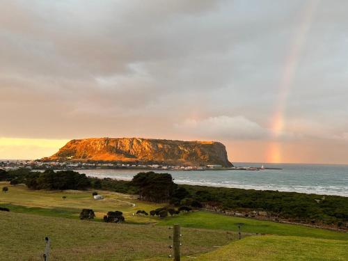 un arc-en-ciel dans le ciel au-dessus de l'océan dans l'établissement Beachscape, à Stanley