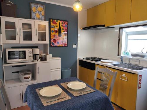 a small kitchen with a table with two plates on it at saunalu in Kido