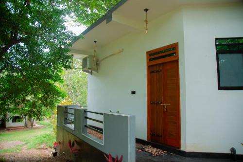 a white house with a wooden door and a porch at Mond Villa Weligama - Private Surf & Nature Stay near Beach in Weligama