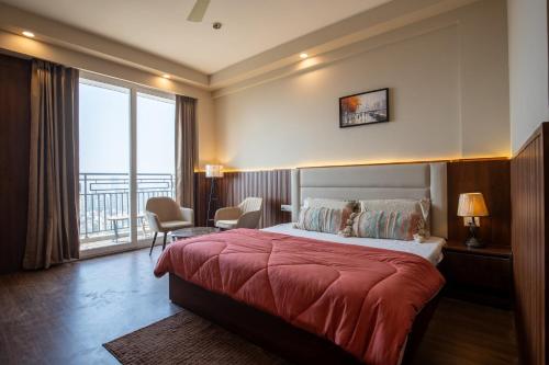 a hotel room with a bed and a balcony at The Sterling Omaxe Near Expo Mart in Greater Noida