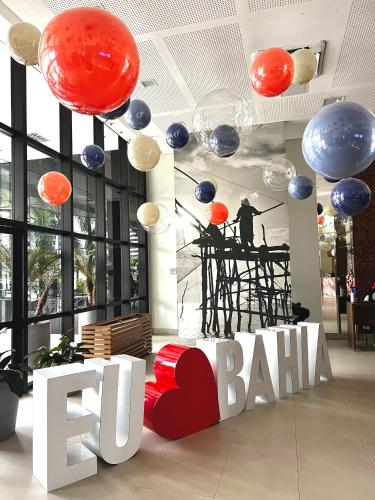 a lobby with a ted baker sign and a man on a stage at Mercure1906 - Piscina aquecida, edifício com estrutura de hotel 4 estrelas in Salvador