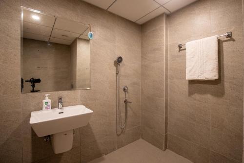 a bathroom with a sink and a shower at The Sterling Omaxe Near Expo Mart in Greater Noida