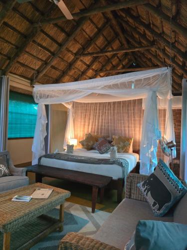 a bedroom with a bed with a canopy at Thornicroft Lodge - South Luangwa in Mfuwe
