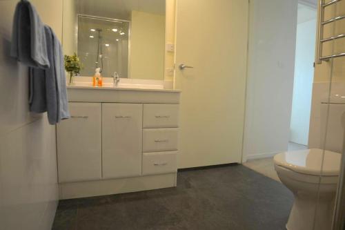 a white bathroom with a sink and a toilet at Prime Luxury Penthouse Living in Launceston
