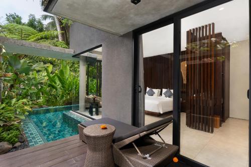 a house with a swimming pool and a bedroom at The Ning Resort Ubud in Ubud
